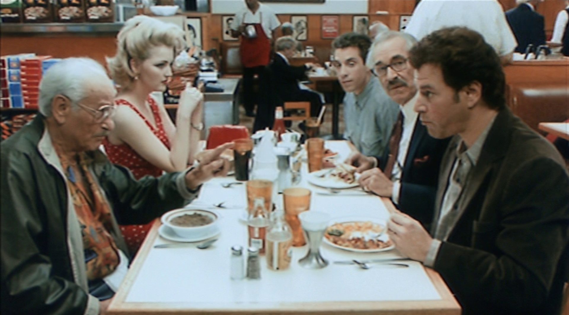 Die drei Filmemacher im Gespräch mit einem potenziellen Investor und dessen Freundin in einem Restaurant.
