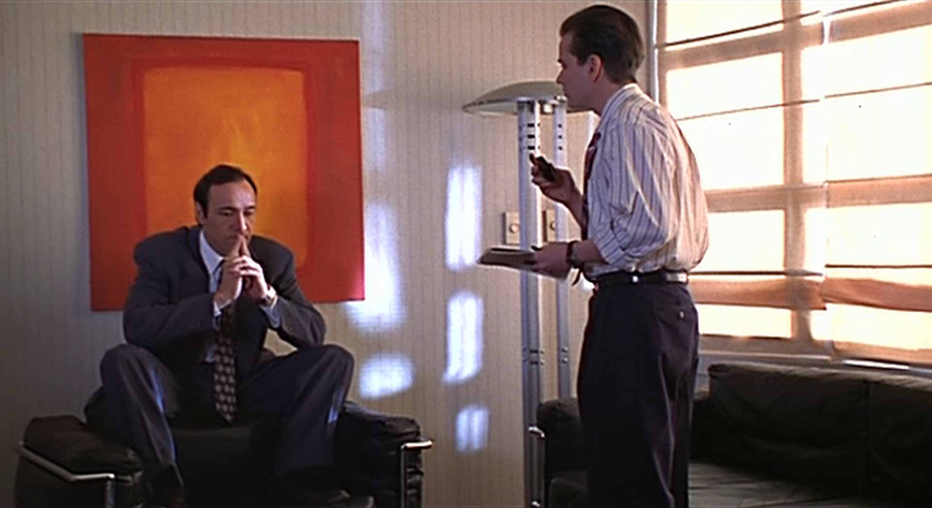 Spärlich ausgeleuchtetes Büro: Kevin Spacey hockt in nachdenklicher Pose auf einem schwarzen Manhattan-Sessel vor einem Rothko-ähnlichen Gemälde, vor ihm steht im Yuppie-Look Frank Whaley als junger Assistent Guy.