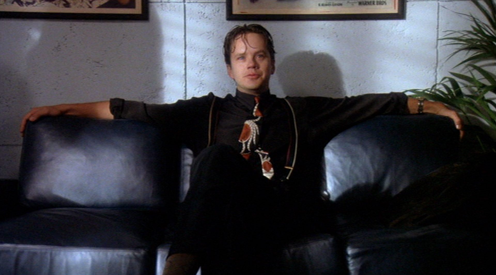 Tim Robbins als Filmproduzent Griffin Mill auf der Couch in seinem Büro.
